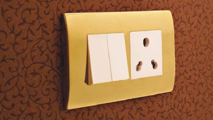 gold and white types of electrical switches on red wallpaper