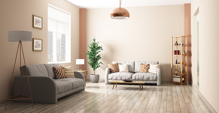 light coloured floor to make the living room with grey couches and light pink walls look bigger