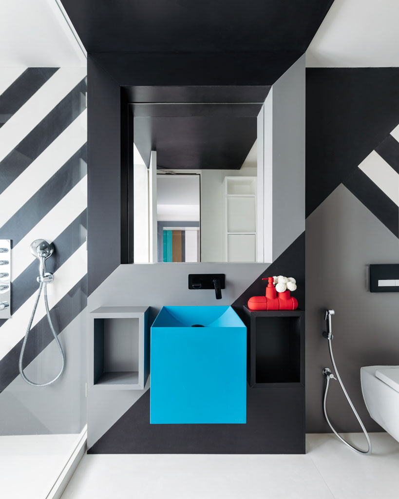 budget modern small bathroom idea with bold black graphics on wall, blue wash basin, mirror, shower