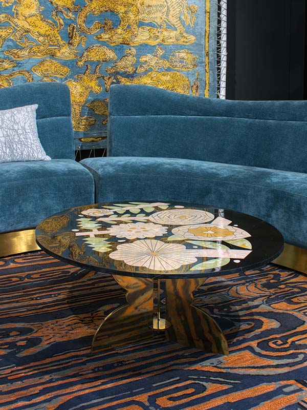 designer centrepiece, with glass table top, printed design, printed floor, velvet sofa, printed beautiful wall, gold faux base