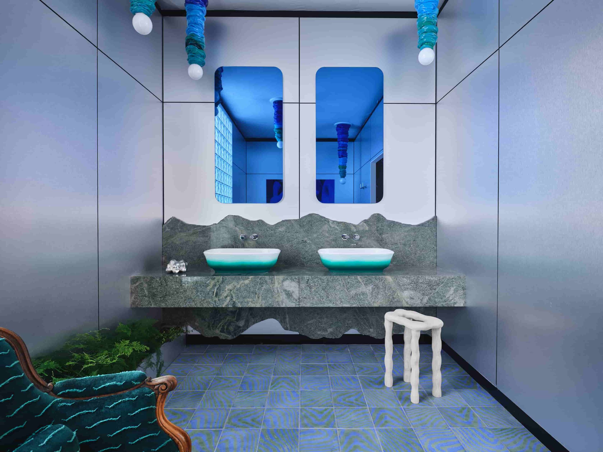 bold and beautiful compact restroom, with two mirrors, washbasin, marble counter, tiled floor
