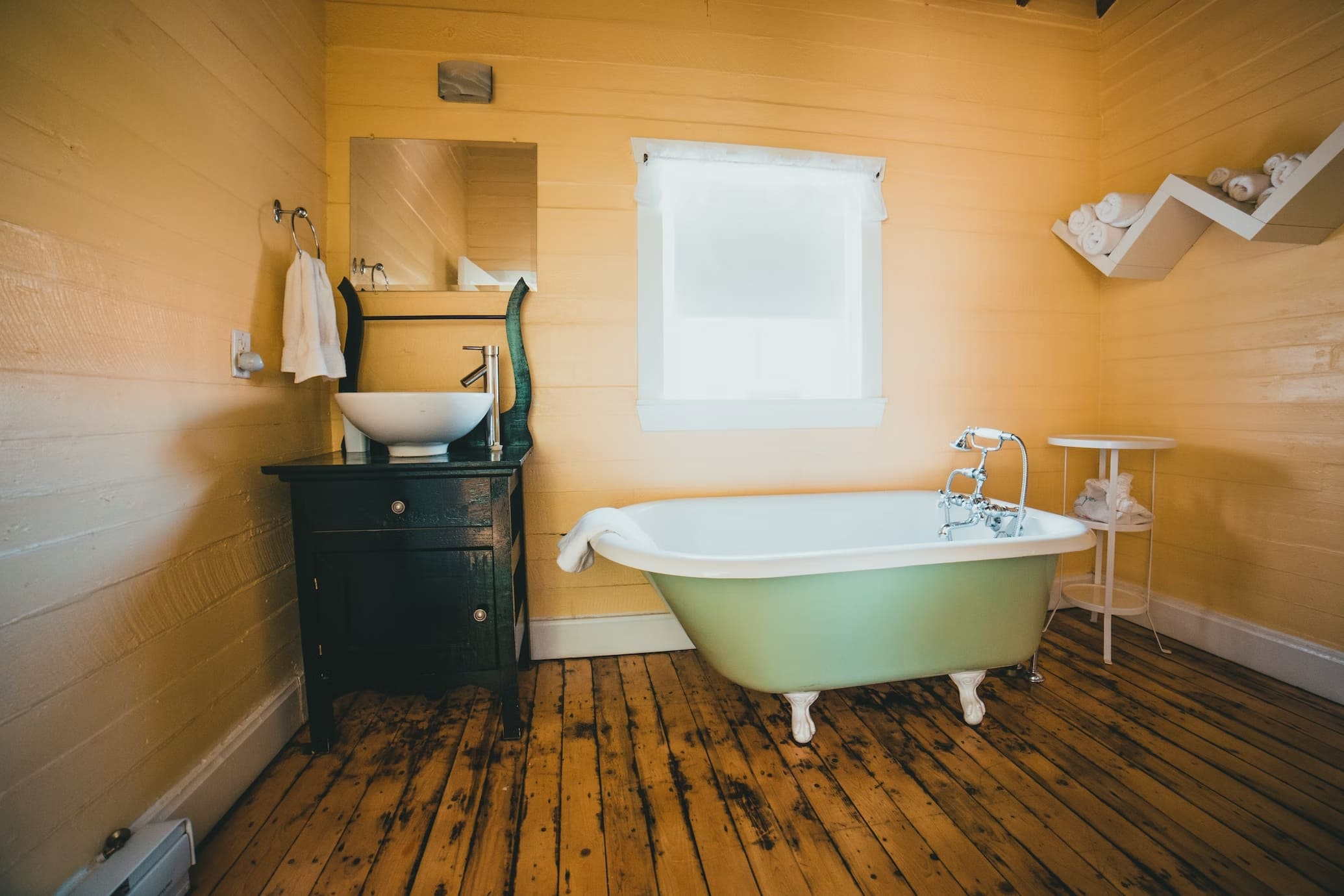 country style bathroom, with pastel colour bathtub, natural light through window, mirror