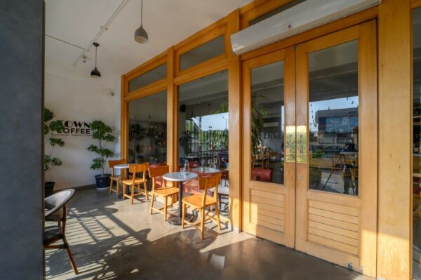 espresso bar in jaipur made by park hospitality with furniture made of sustainable materials in brown door panels, chairs and table