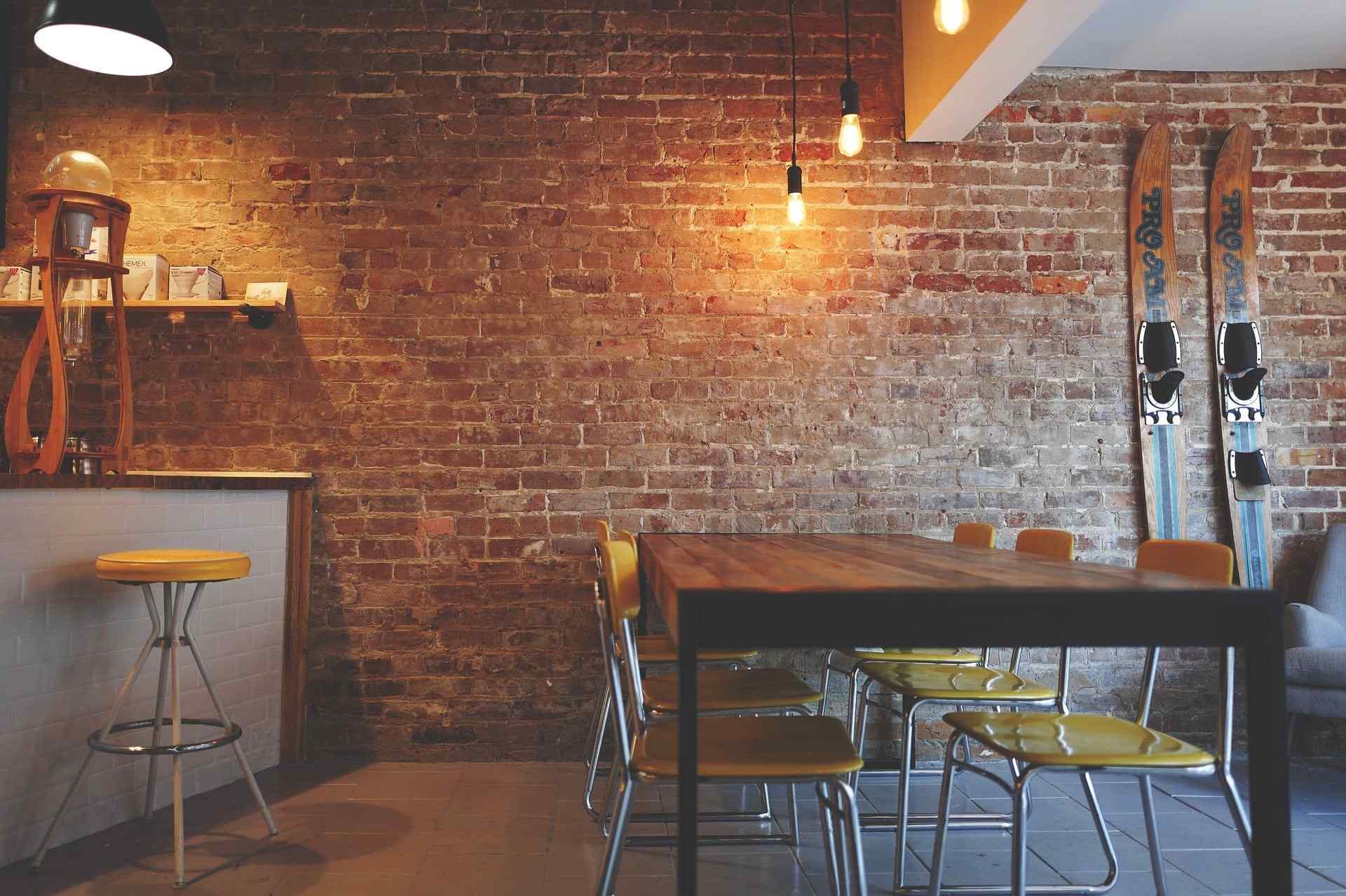 brick wall in a cafe with brown table and chairs