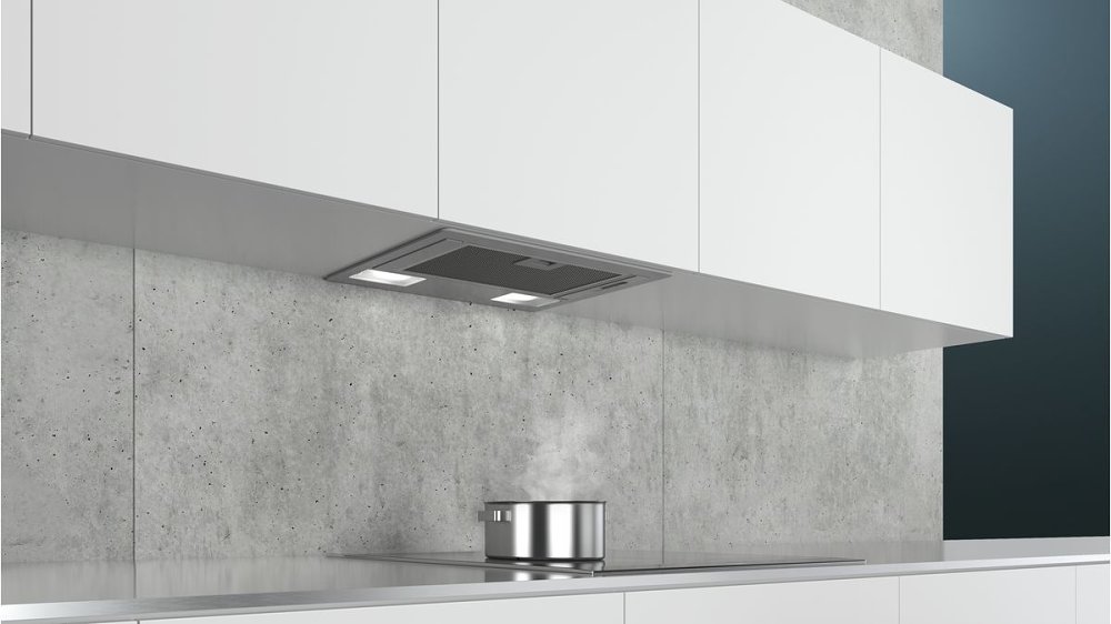 built-in canopy or under-cabinet cooker hood in a minimalistic white kitchen, modern modular kitchen chimney design