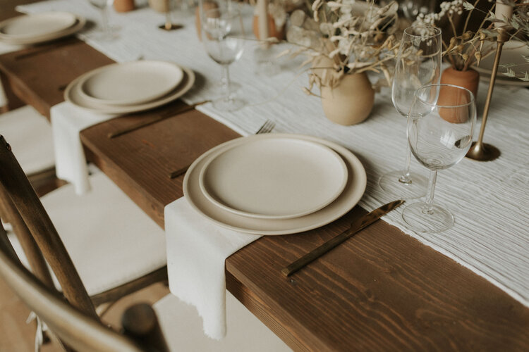 brown dining table with a white tablecloth, Cutlery, plates, napkins and glasses elegant dining table setting decor ideas