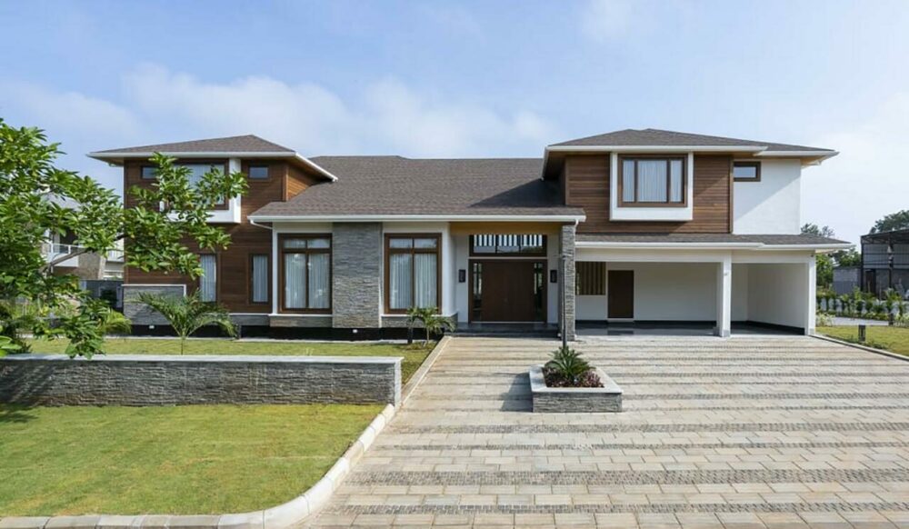 brown canadian wood villa with green garden and trees given Sustainable project of the year award given at National Awards for Leadership and Excellence world HRD congress to canadian wood villa built by MAK projects