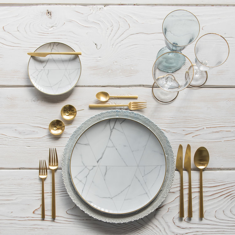 white wooden dining table with Cutlery, plates, and glasses