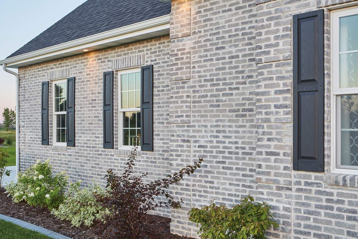 country side ،me with exposed fly ash bricks wall blue roof and plants 