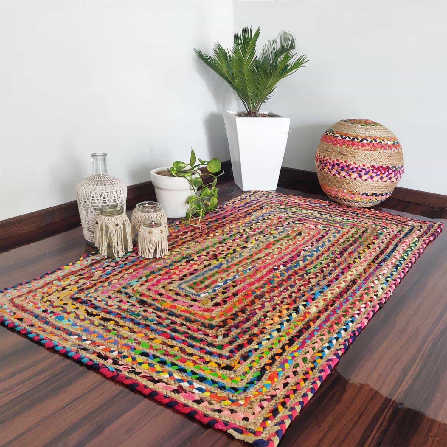 beautiful hand woven carpet, placed in a hall, white coloured planter placed in corner