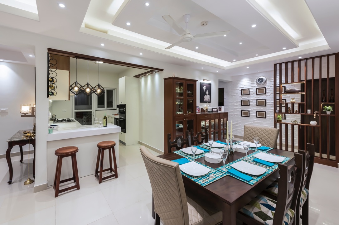 white dining room with table, chair, fan and kitchen view