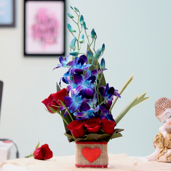 blue blossoms, placed on a table, painting hanging on wall