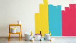 Painting the walls with yellow, blue, and pink.
