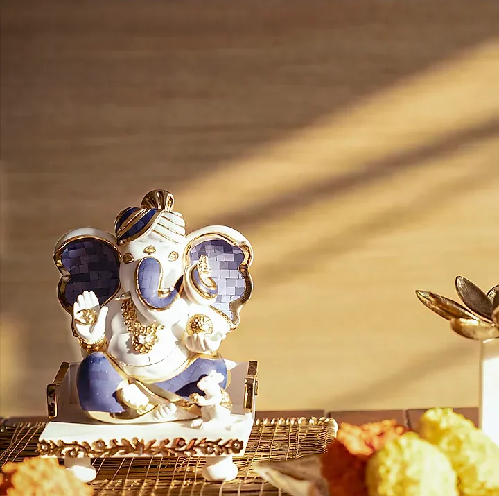 a seated white Ganesha murti or photo, crafted in resin and marble dust with a lapis lazuli inlay and gold plating.