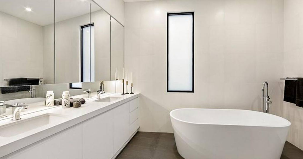 Lavish white bathroom with a tub and other acessories