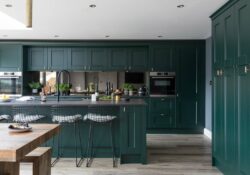 dark green shaker kitchen cabinets and island with stainless steel appliances