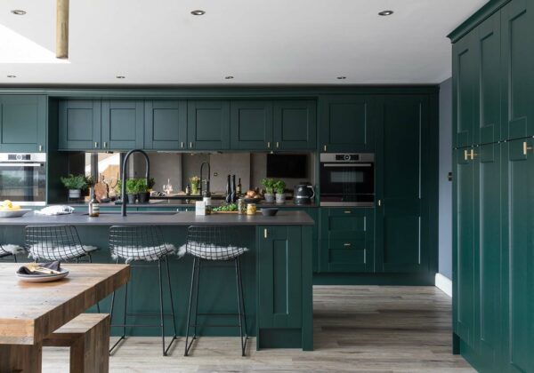 dark green shaker kitchen cabinets and island with stainless steel appliances