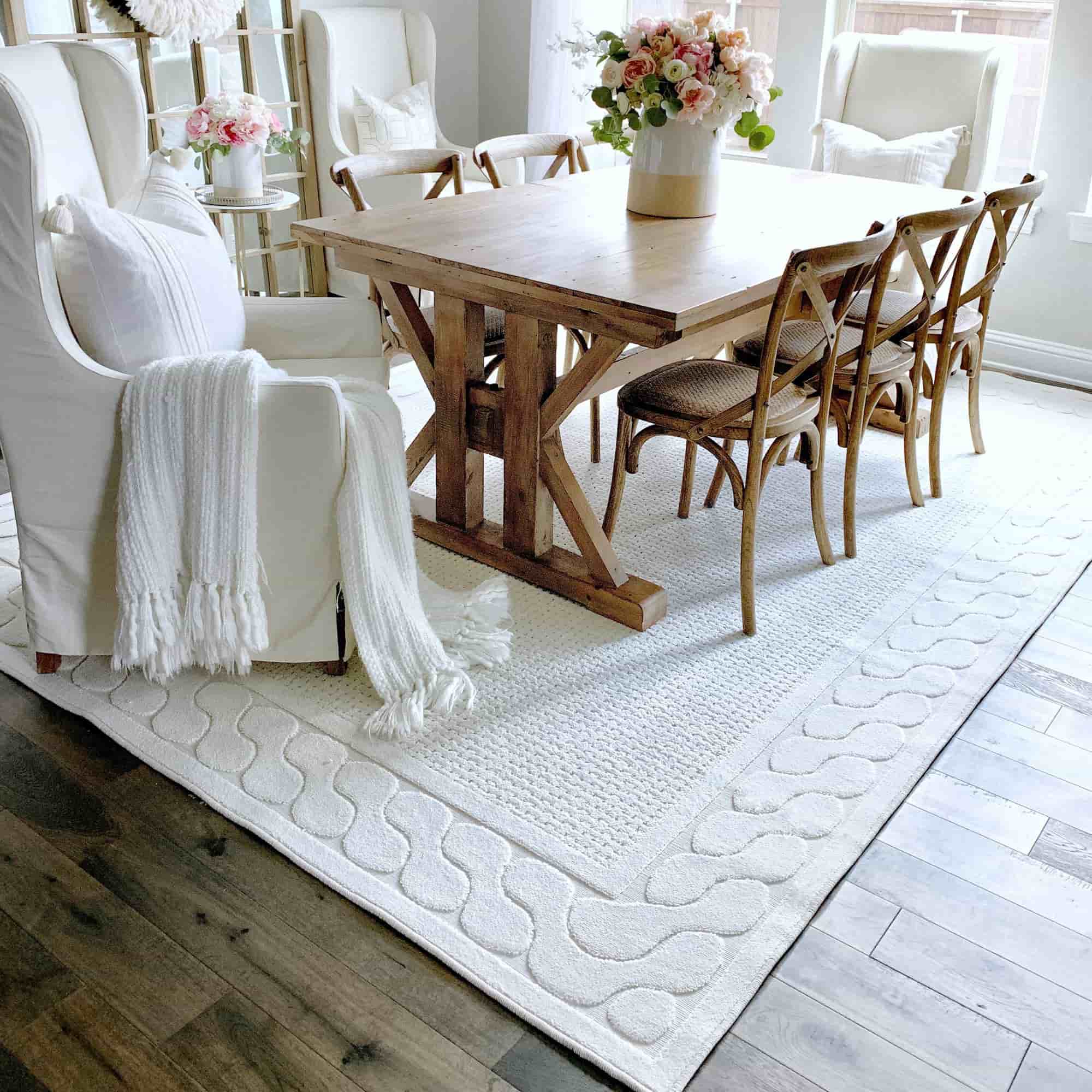 elegant white carpet under the dining table, wooden furniture, white chair, flower setting on table