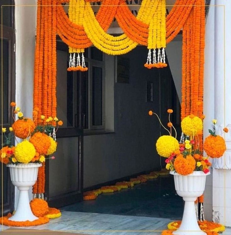Orange and yellow artificial decor flowers and flower pots, and marigold garlands for entrances