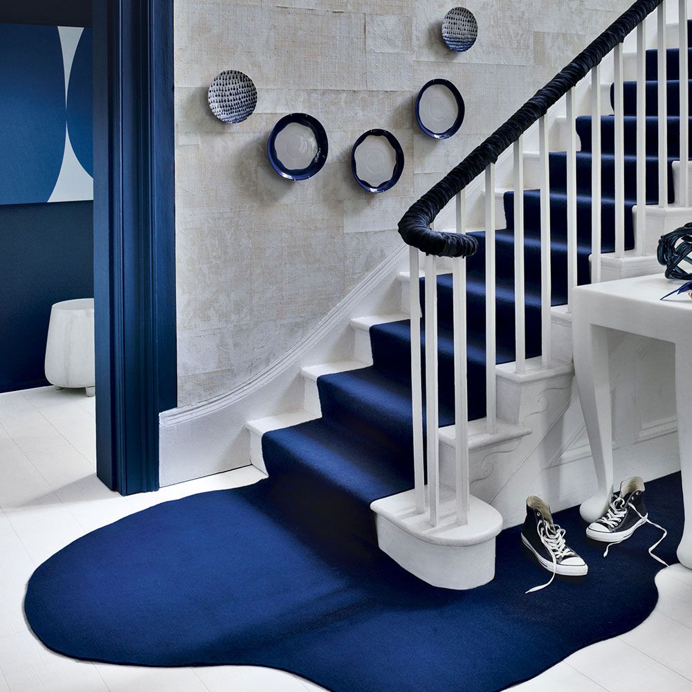 bold and royal carpet for your staircase, blue coloured carpet, classic blue and white colour combination, wall decoration with show piece and wallpaper