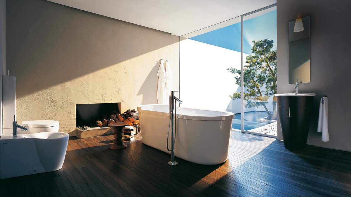 brown wooden floors in a bathroom with white bathtub and plants