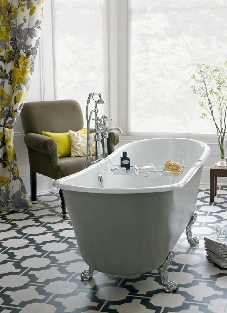 white bathtub with designer floor, chair and table