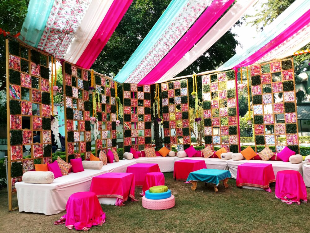 Haldi decoration with coloirful fabrics and low seating.