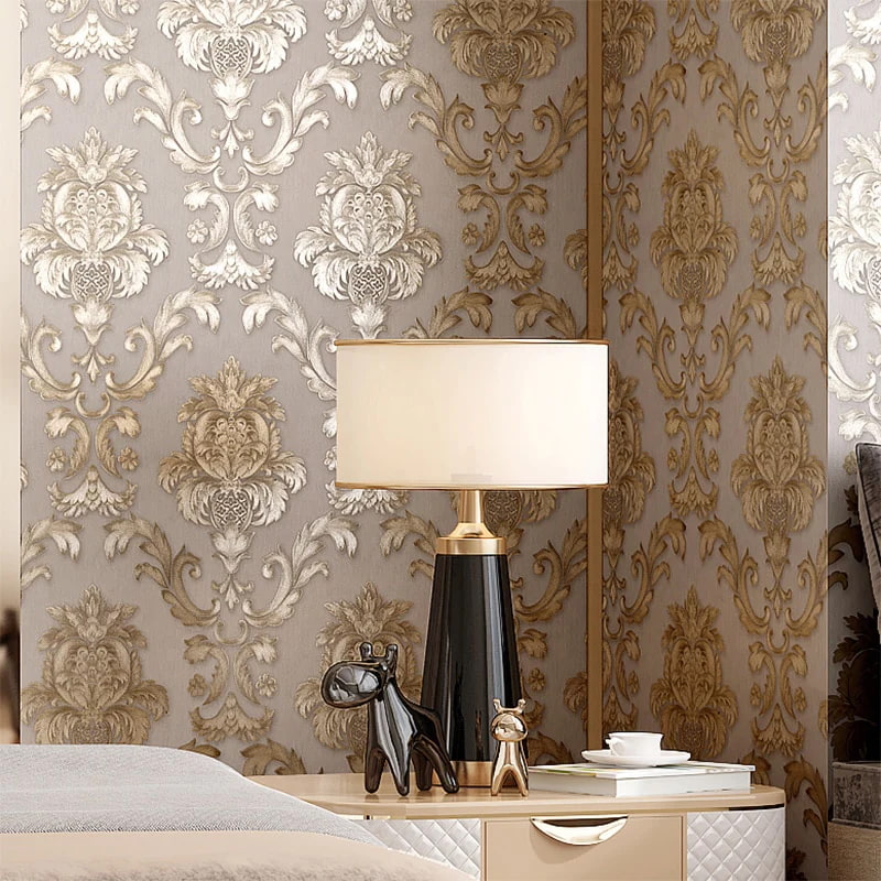 gold metallic wallcovering for your bedroom, bedside table with a lamp placed in it, beautiful designs intricate on the wall