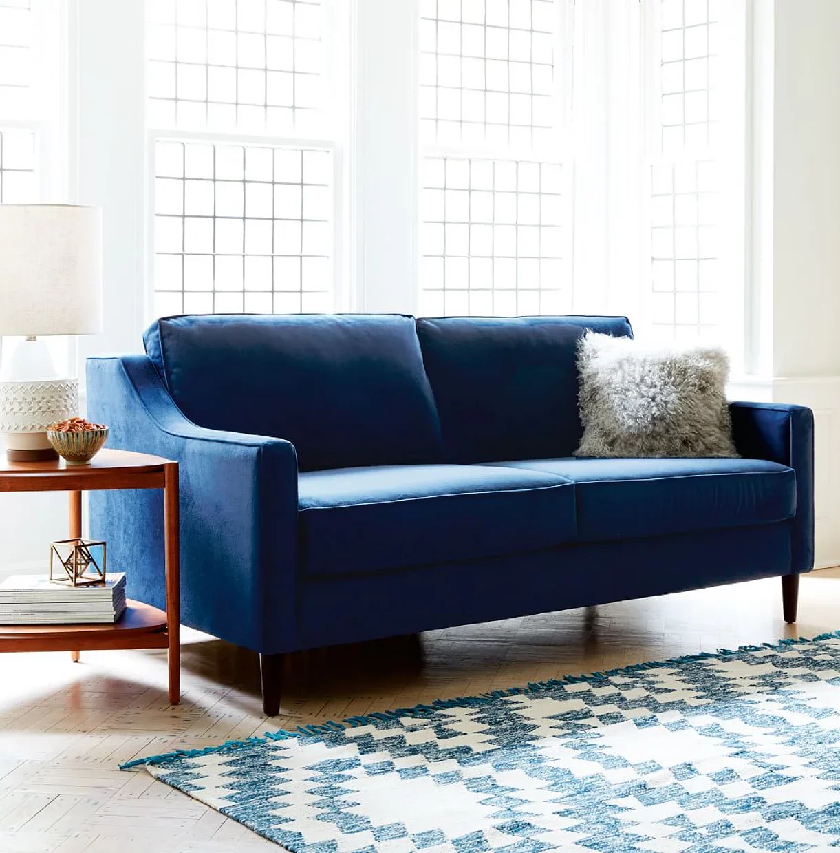ink blue coloured latest sofa set design, placed in a living room, sky blue coloured carpet placed under the furniture, wooden side table placed near the couch