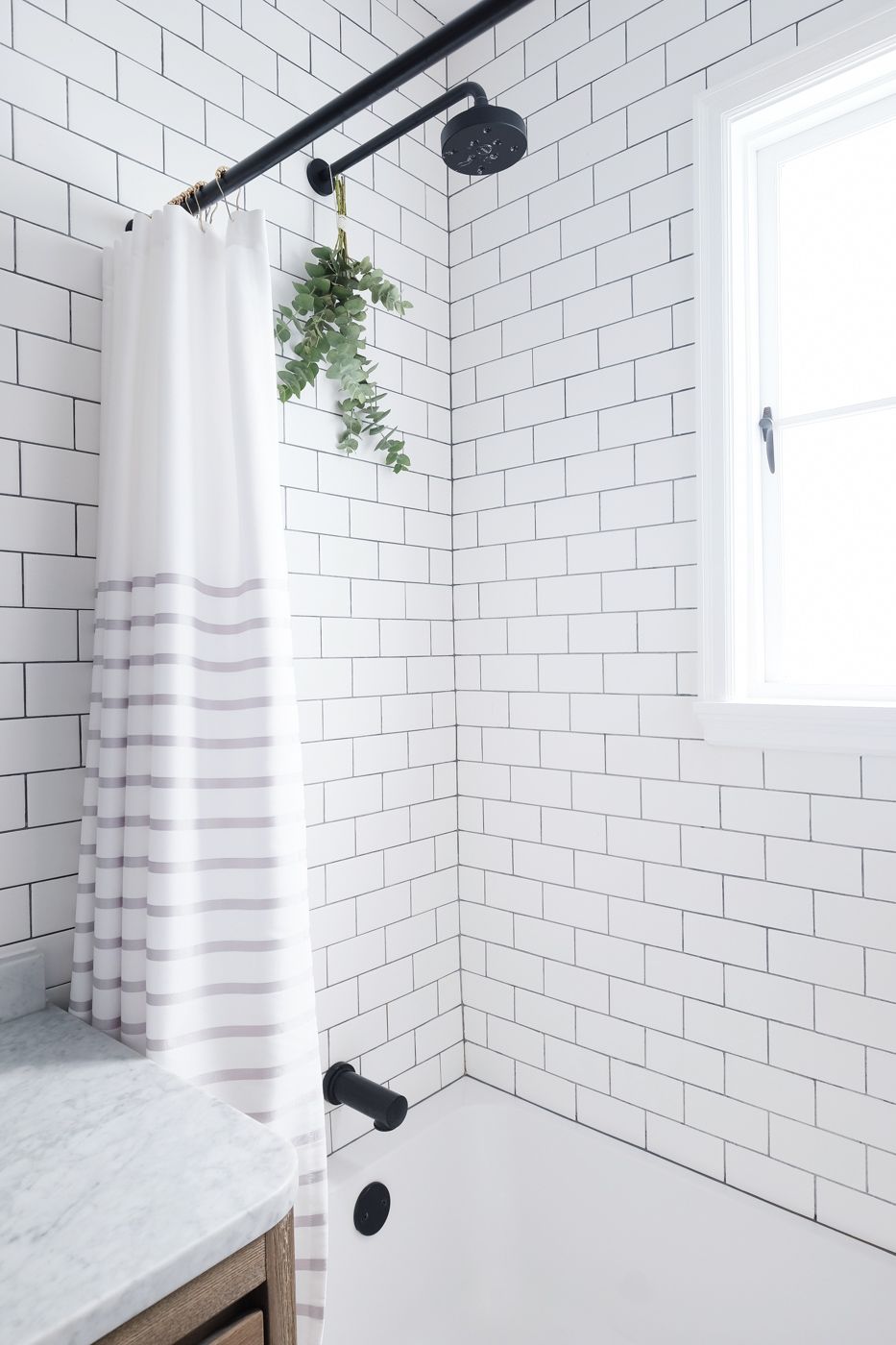 Beautiful all white washroom with a window and a small plant