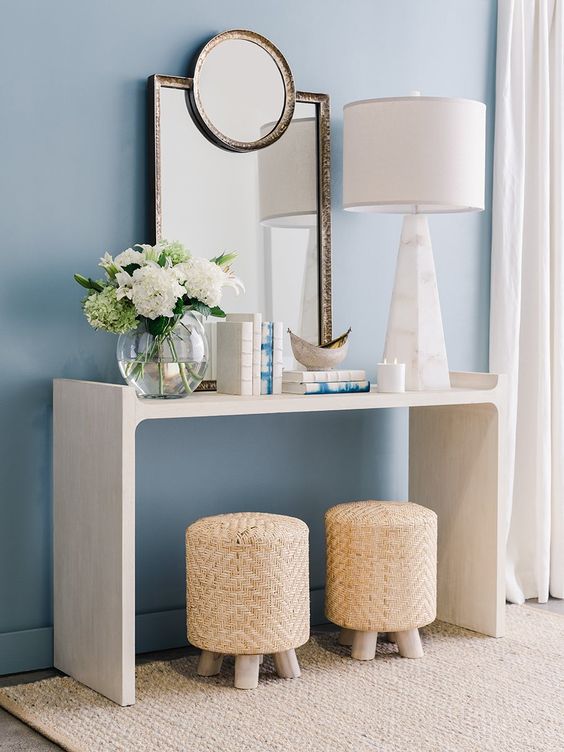 rattan stools paired with modern console table, a table lamp placed on it, mirror