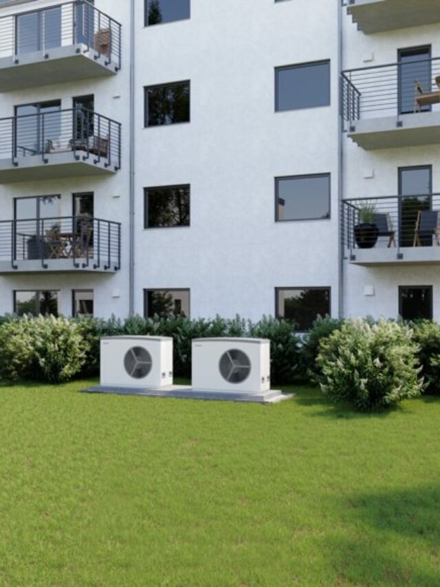 white Air source heat pump Stiebel Eltron in a garden outside a white building