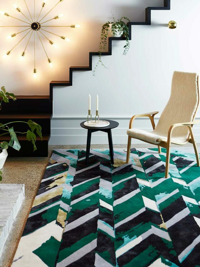 green and white rug in a living room with chair, table, stairs and wall lights