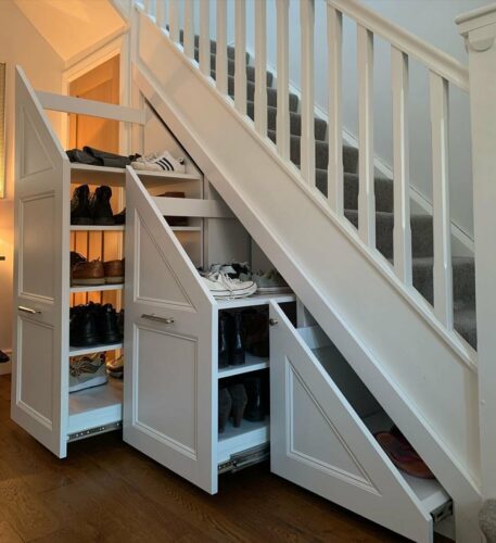 beautiful white storage under staircase