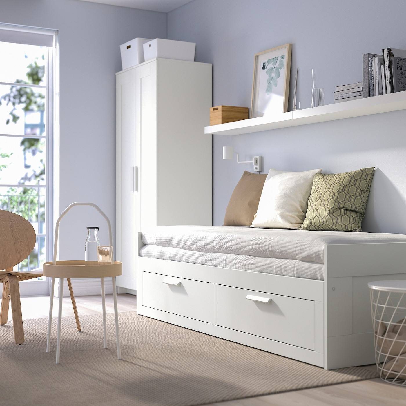 white bed in a small bedroom with table and chair and a brown rug