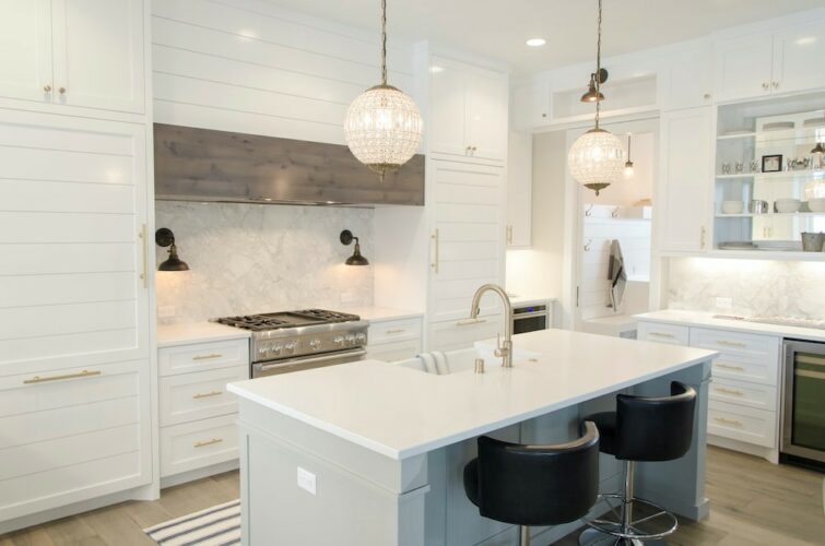 white kitchen with pendant lights and an island