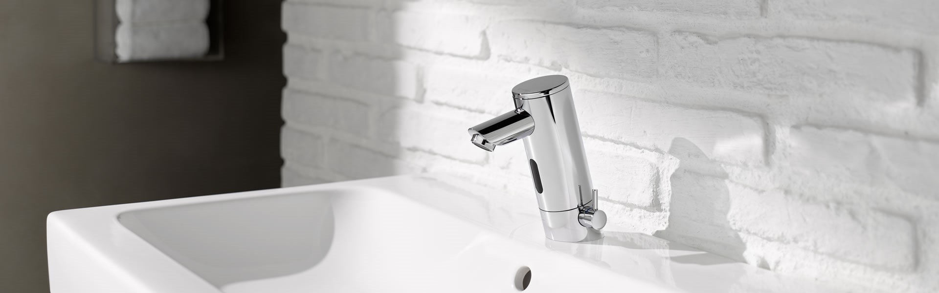 silver schell touchless tap in a washroom with white sink