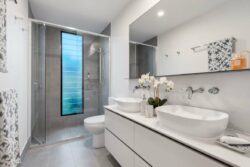 small bathroom with white tiles and cabinets