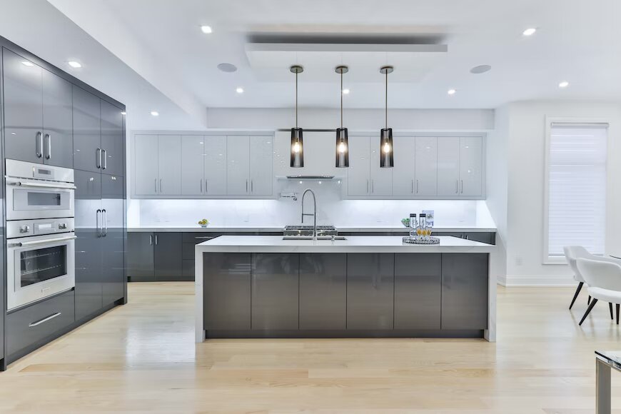 modern kitchen design in white and grey with a workstation sink in the middle and ceiling lights