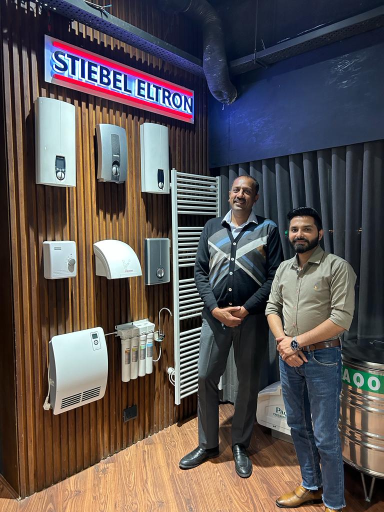 Pankaj Jain with his team in his showroom standing in front of a brown display wall