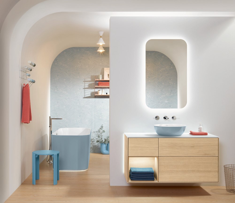 white bathroom with a mirror, washbasin, brown cabinet, blue bathtub,