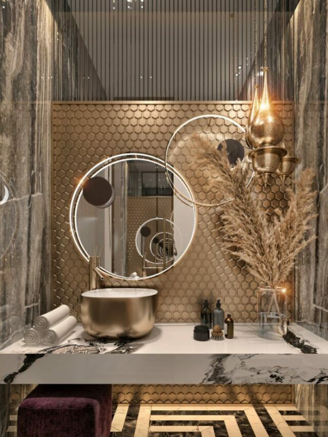 Golden washbasin in a bathroom with a round mirror and towels