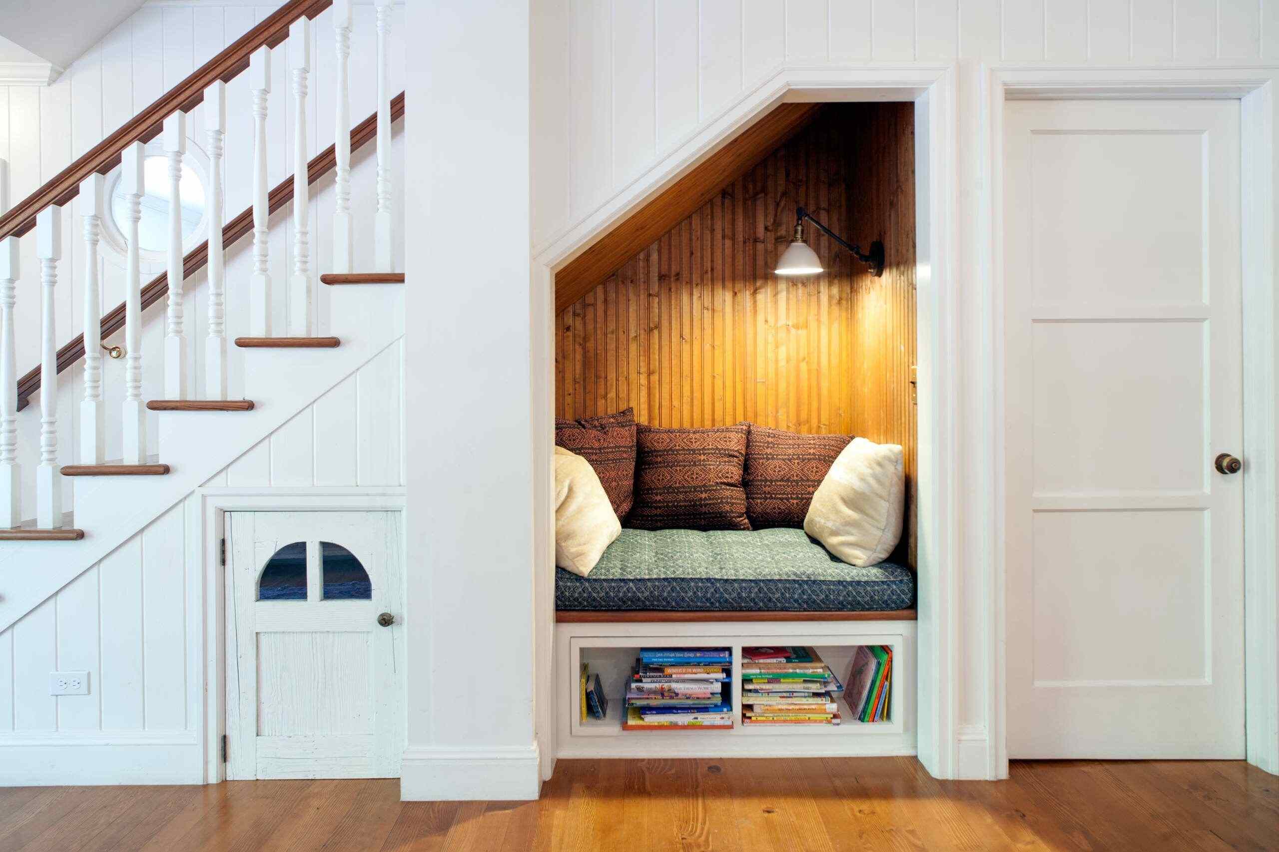 cozy staircase nook, hanging light, white stairs, cushions, wooden flooring