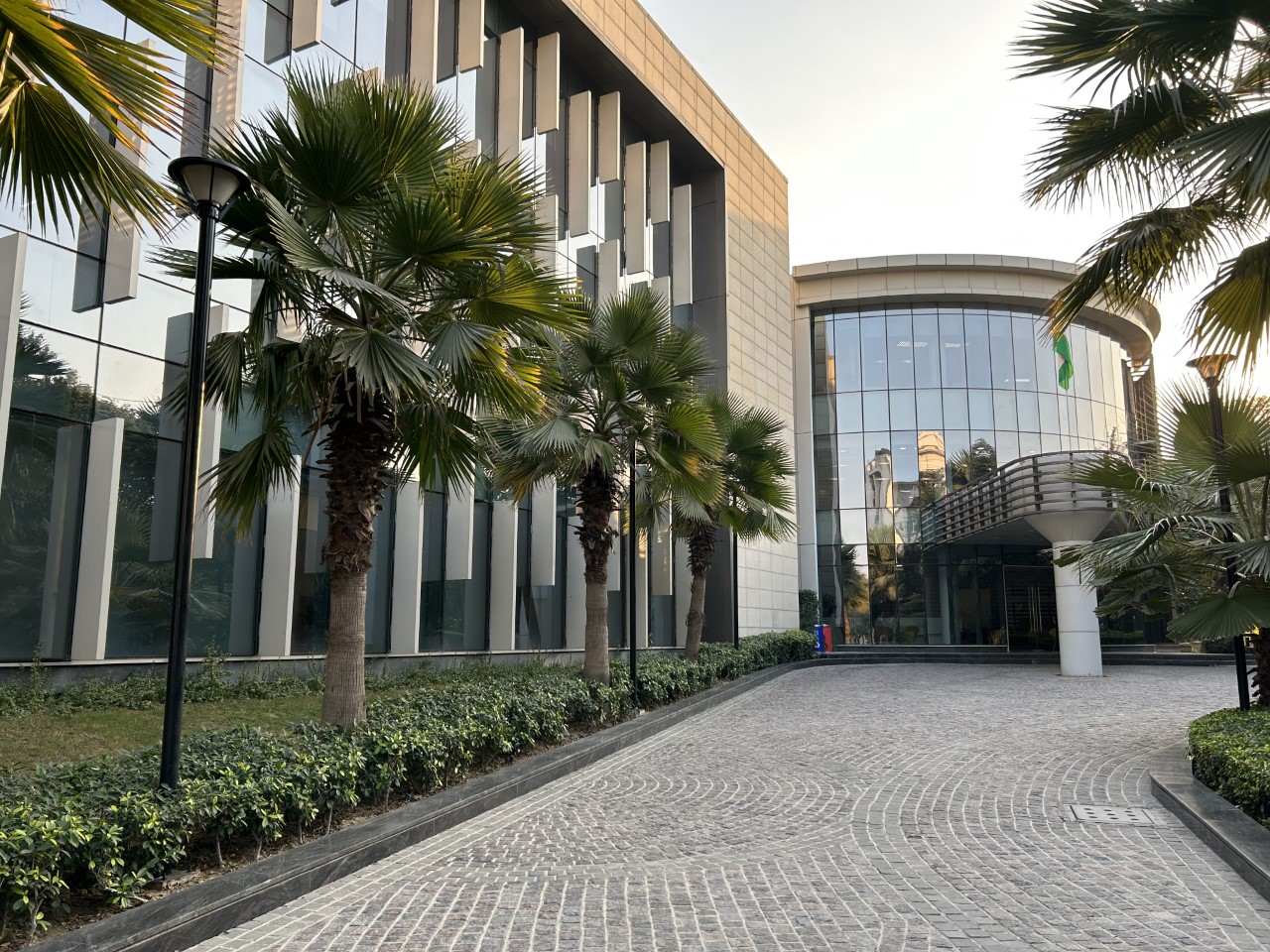 green building, glass. nature presence, glass, beautiful driveaway space