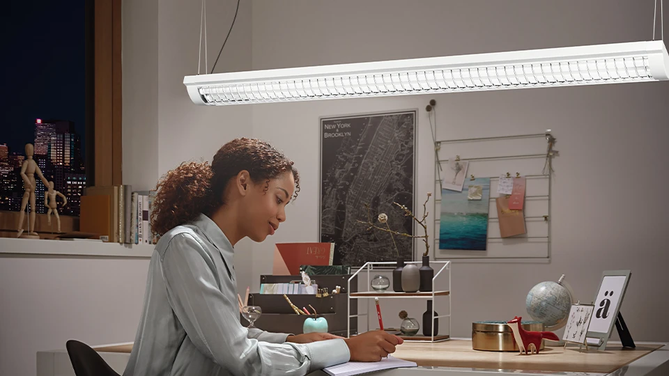person working under led light at home office