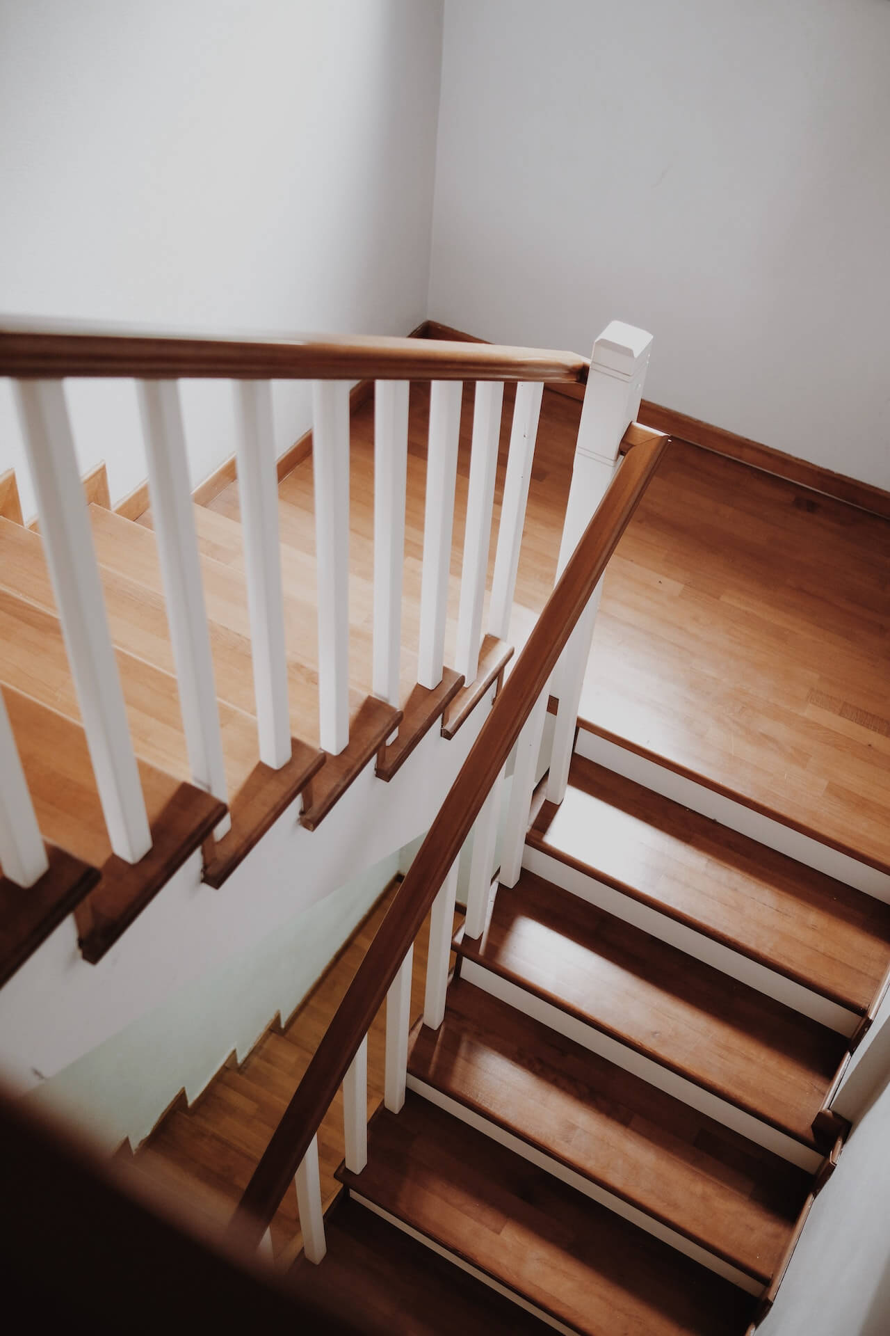 wooden stairs leading upward, wooden steps with white metal railings, simple staircase design