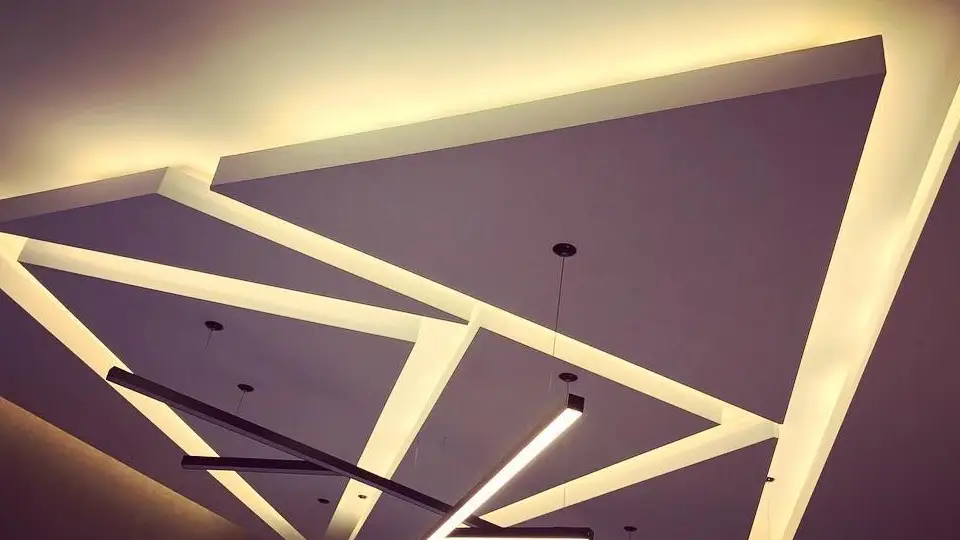 Neat cuts in the false ceiling design are enhanced with coved lighting.