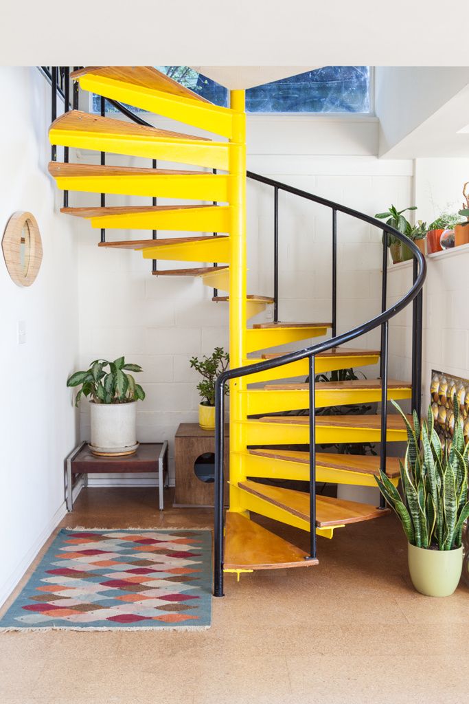yellow stairs, metal railing, indoor plants, rug, wooden flooring
