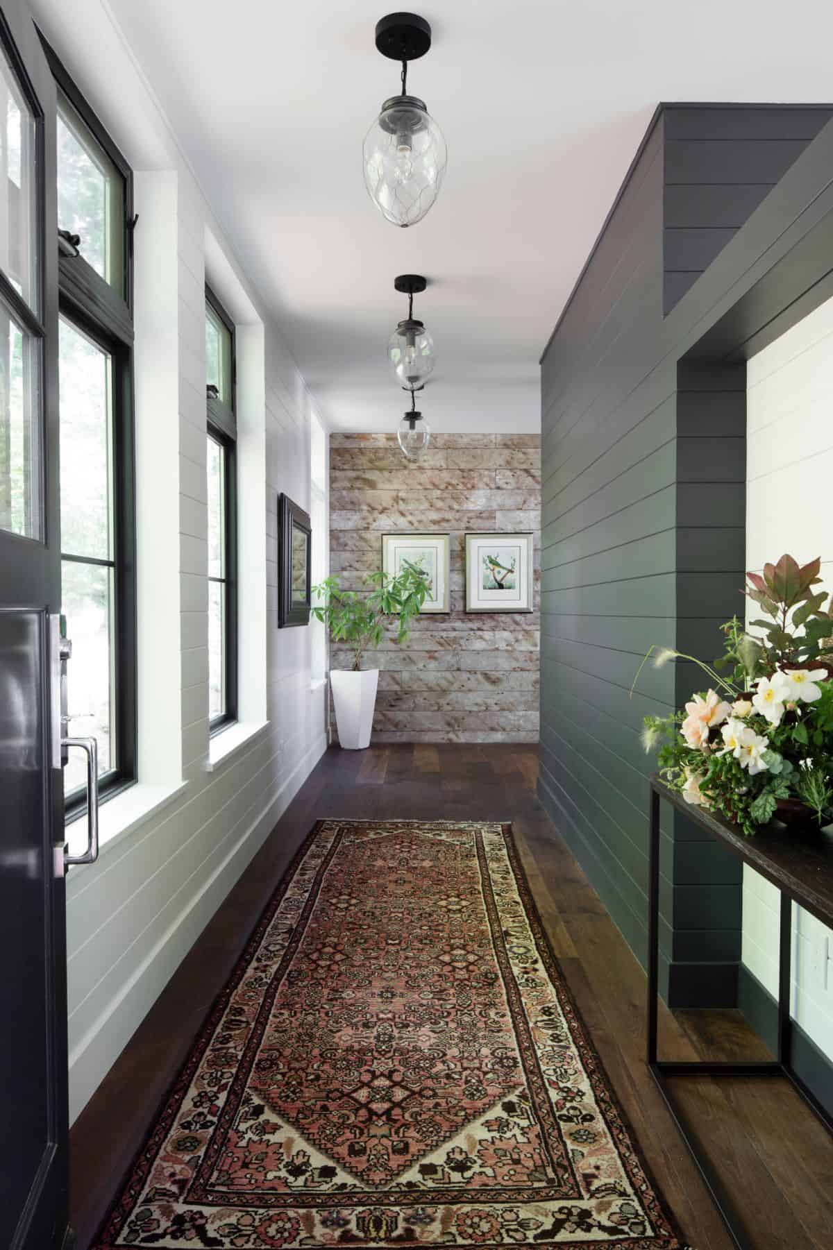A hallway with an accent wall paint design idea plants and windows