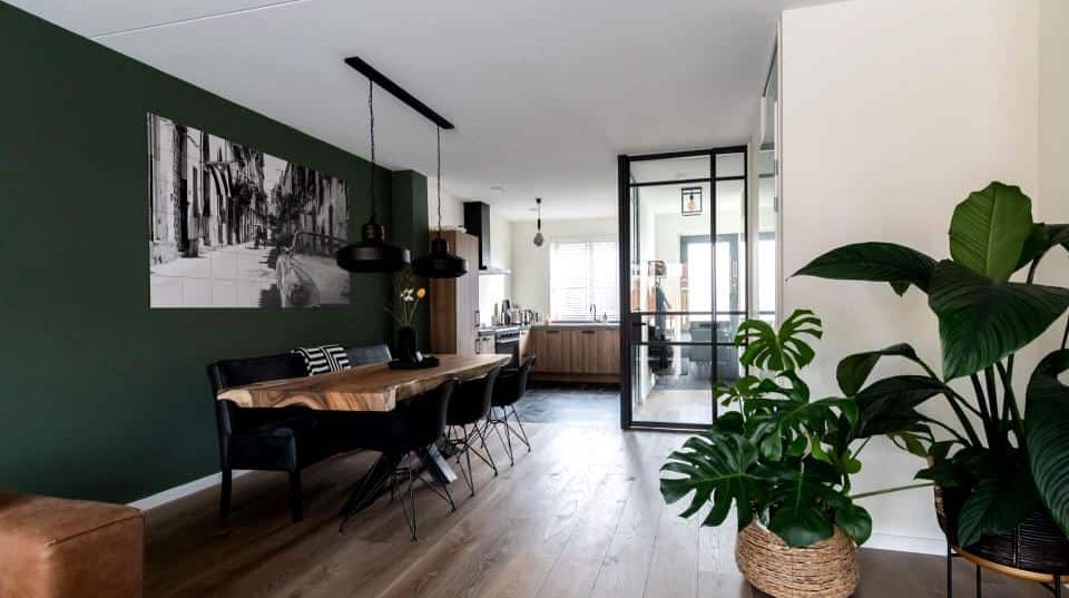 White and dark green hall with plants and furniture